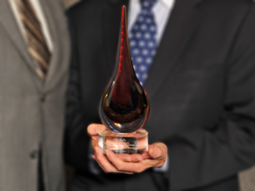 man in suit holding trophy