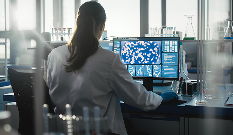 A person sits at a computer in a laboratory 